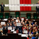 Opposition lawmakers sing the national anthem and chant as they occupy the podium to protest in the lower house of parliament in Warsaw, Poland, on Friday, 16 Dec. 2016. They protested in a large group around the podium against the ruling party pans to limit reporters' access to lawmakers. (AP Photo/Czarek Sokolowski)